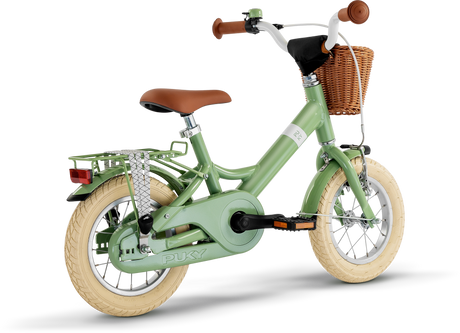 PUKY Barncykel - 12" - 3 år - 1 Gear, eller Puky Youke 12 Classic, är en charmig grön cykel för barn runt 3 år. Den har krämfärgade däck, ett brunt säte, flätad korg på styret, ett bakre metallställ, träningshjul och ett kedjeskydd.