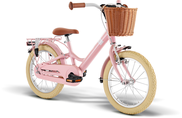 PUKY Barncykel Youke 16 Classic är en snygg rosa cykel för barn från 4 år med lätta funktioner, inklusive en brun flätad korg och bruna däck. Den har brunt styre, en bekväm sadel och ett bakre metallställ, allt med en vanlig vit bakgrund.