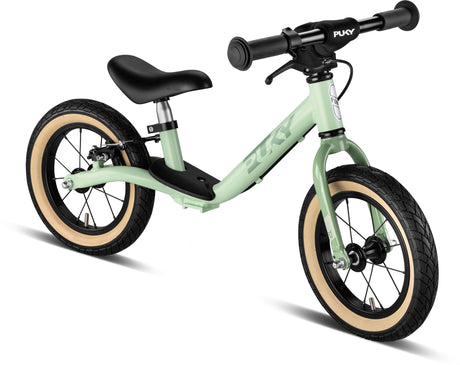 En ljusgrön PUKY LR Light_Br balanscykel med svart styre, svart säte och svarta däck med vita fälgar. Cykeln har lufthjul för en mjukare körning och har en låg, genomgående ramdesign, med varumärket "PUKY" synligt på ramen och styrplattan.